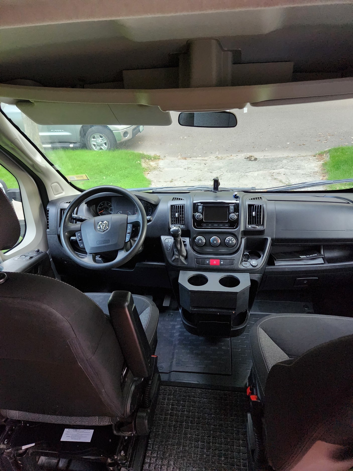 This RV rental's cockpit shows the steering wheel, dashboard, and front view from inside.