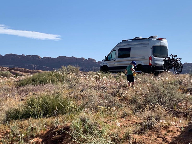 a camper van's dining area is set with a table for four. Swivel seats create a functional space.|RV rental camper van interior. A dining table for four is set between the front seats and a rear bench — photo 5