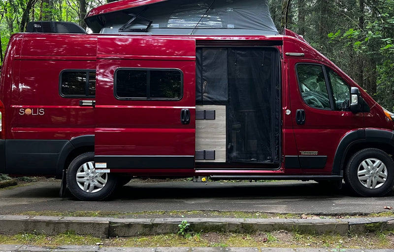  perfect for travel.|A red Winnebago Solis RV rental is parked in a serene forest campground — photo 5