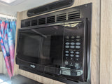 Black High Pointe microwave oven mounted in a wood-paneled wall, common in an RV rental kitchen.