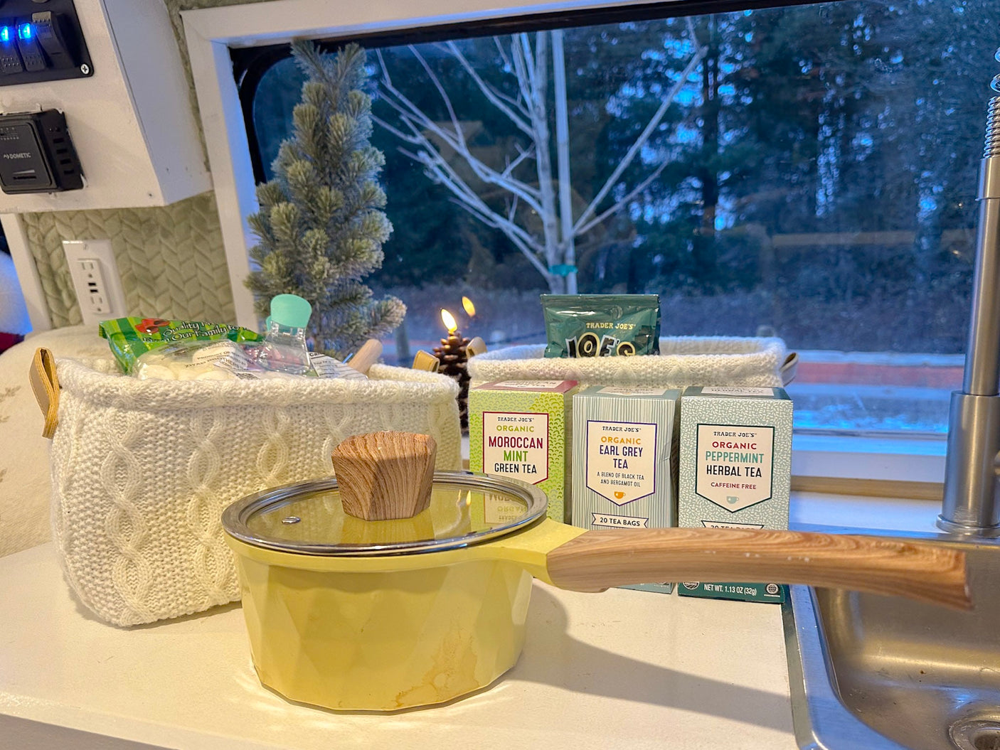Cozy RV kitchen with Trader Joe's teas & pot, featuring a winter window view. Perfect for an RV rental.