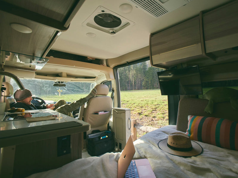  sunlit peaks above dense trees.|RV rental van interior with bed facing majestic snow-capped mountains in a desert landscape. A camera on tripod waits.|RV rental experience: Relax in a spacious camper van — photo 6