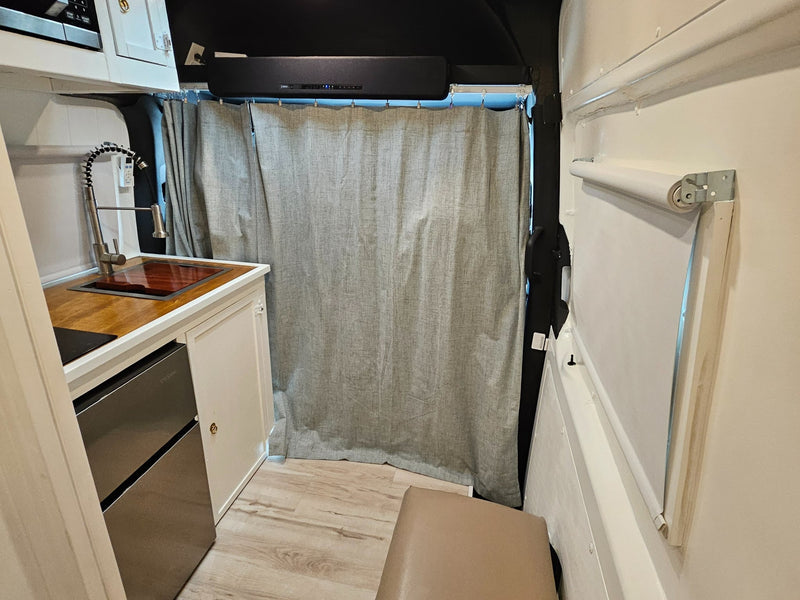  and white paneled walls.|Cozy rv rental bed area featuring a green patterned quilt — photo 10