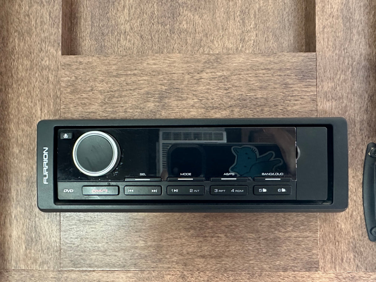 A Furrion RV entertainment system/stereo unit mounted in wood paneling, commonly found in an rv rental. Features DVD & audio controls. — photo 10
