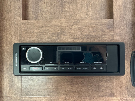 A Furrion RV entertainment system/stereo unit mounted in wood paneling, commonly found in an rv rental. Features DVD & audio controls.
