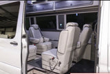 Luxurious custom van interior, perfect for an RV rental. Features premium quilted seating, ample space, and overhead storage.