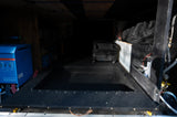 RV rental's utility compartment features a blue inverter, water pump, and organized storage for your travels.