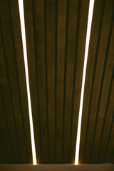 Modern RV rental interior showcasing dark wood slatted walls with bright, integrated LED lighting. Creates a warm ambiance.