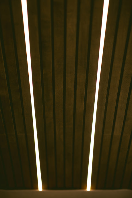 Modern RV rental interior showcasing dark wood slatted walls with bright, integrated LED lighting. Creates a warm ambiance.