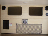 This RV rental interior shows light wood panels, overhead storage, speakers, power outlets, and a propane safety warning.