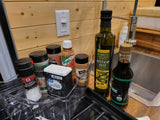 RV rental kitchen: cooking essentials like olive oil, spices, & soy sauce neatly arranged by the sink.
