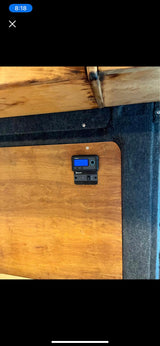 RV rental interior: A digital control panel displays "14.0" on wood paneling, integrated for managing camper van systems.
