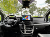 RV rental: Ford van interior featuring a large Apple CarPlay screen, with a scenic lake view outside.