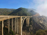 Iconic Bixby Bridge on the California coast, with lush mountains & fog. Perfect for an RV rental scenic drive.