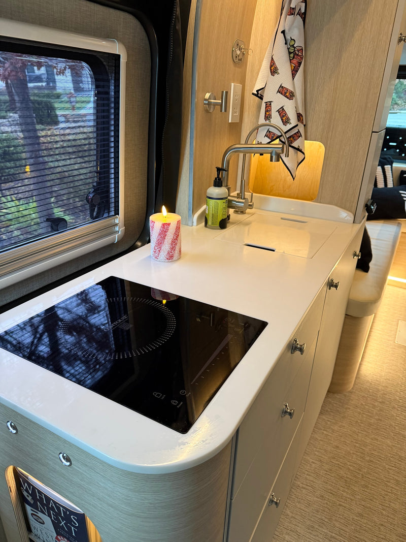  and sink area.|Cozy rv rental interior featuring a foldable wooden table — photo 6