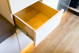 RV rental storage: An open wooden drawer with white trim and subtle under-cabinet lighting, showcasing compact interior space.