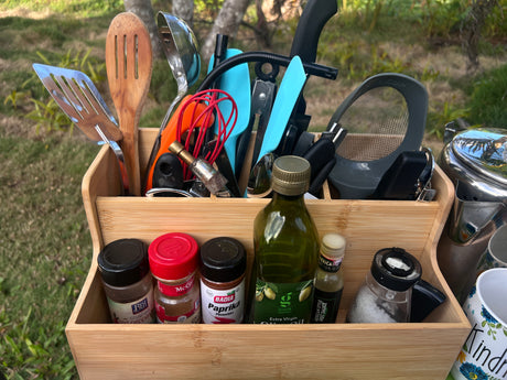 A portable wooden caddy with cooking utensils, spices, and oils, perfect for outdoor meals during your RV rental.