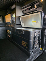 This RV rental's organized interior features an ICECO fridge/freezer, modular storage, and a safety extinguisher.