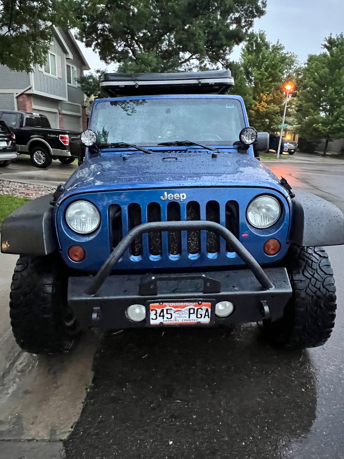 Front of a blue Jeep Wrangler with a roof tent, perfect for an RV rental and outdoor adventures.