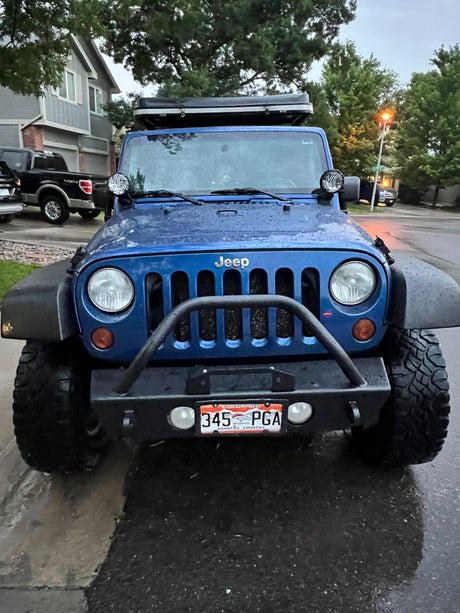 Front of a blue Jeep Wrangler with a roof tent, perfect for an RV rental and outdoor adventures.