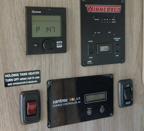 RV rental control panel overview: Truma, Winnebago, Xantrex Solar, and LP valve switches for managing RV systems.