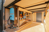 RV rental's advanced power system with Victron inverter, battery bank, and solar charge controllers in a clear enclosure.