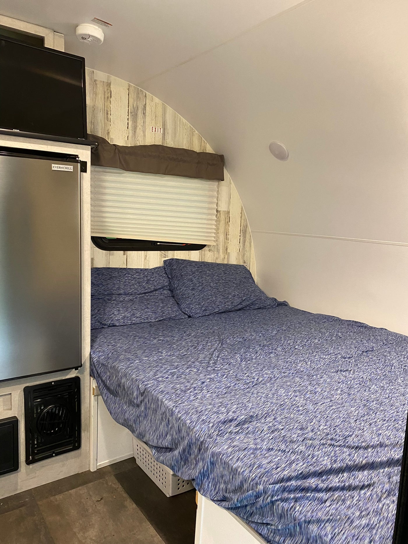 Inside a compact RV rental: a comfortable bed, mini-fridge, and TV make for cozy travel. — photo 8