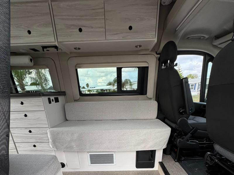  showing the gravel outside and a fire extinguisher mounted inside on the interior wall.|Modern RV rental interior. View from living area to cockpit — photo 13