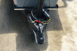 Essential components for an RV rental: close-up of a trailer hitch, featuring the coupler, safety chains, and electrical connector.
