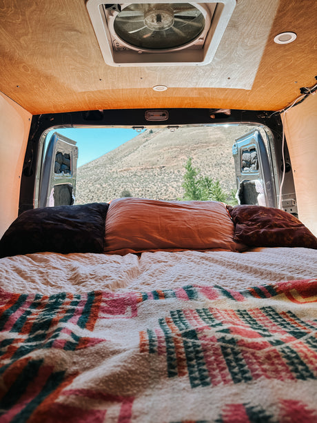 Experience van life! This RV rental offers a comfy bed, ceiling fan, and a breathtaking mountain view from open back doors.