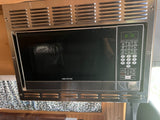 Stainless steel Greystone microwave with a digital display and control panel, ideal for an RV rental or camper kitchen.