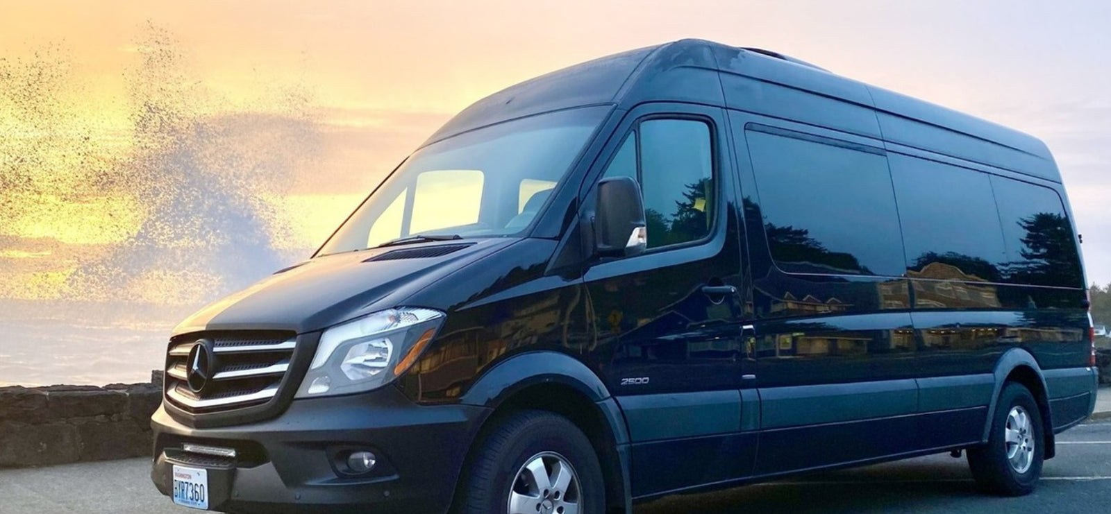 Black Mercedes Sprinter van RV rental by the ocean at sunset with crashing waves. Perfect for road trips and adventure.