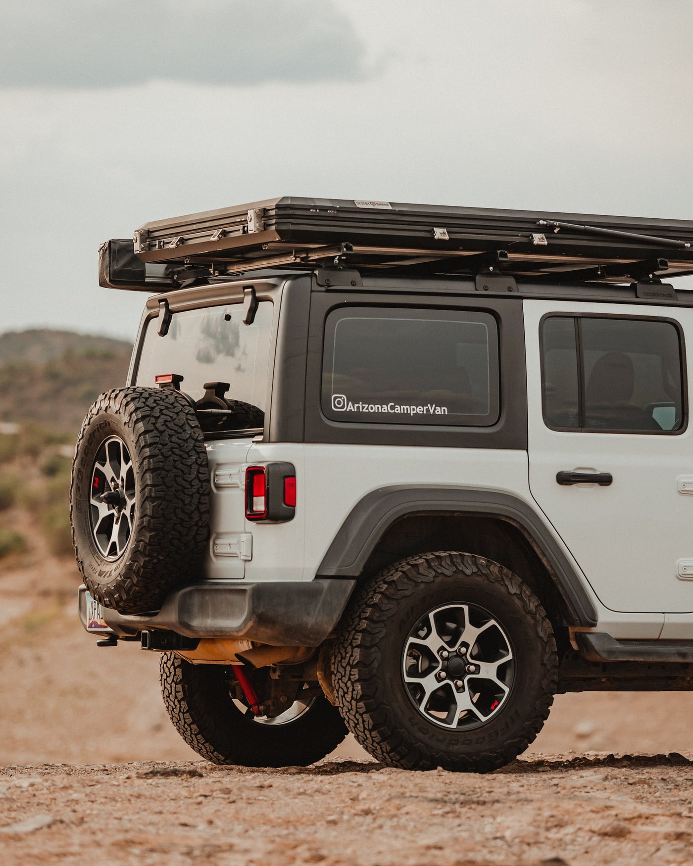 White Jeep overlanding vehicle with rooftop tent on desert terrain, ready for your RV rental adventure. — photo 5