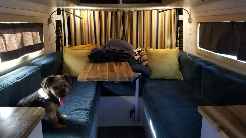  looking towards the driver's cab.|RV rental: customized camper van interior with a light wood folding table — photo 13