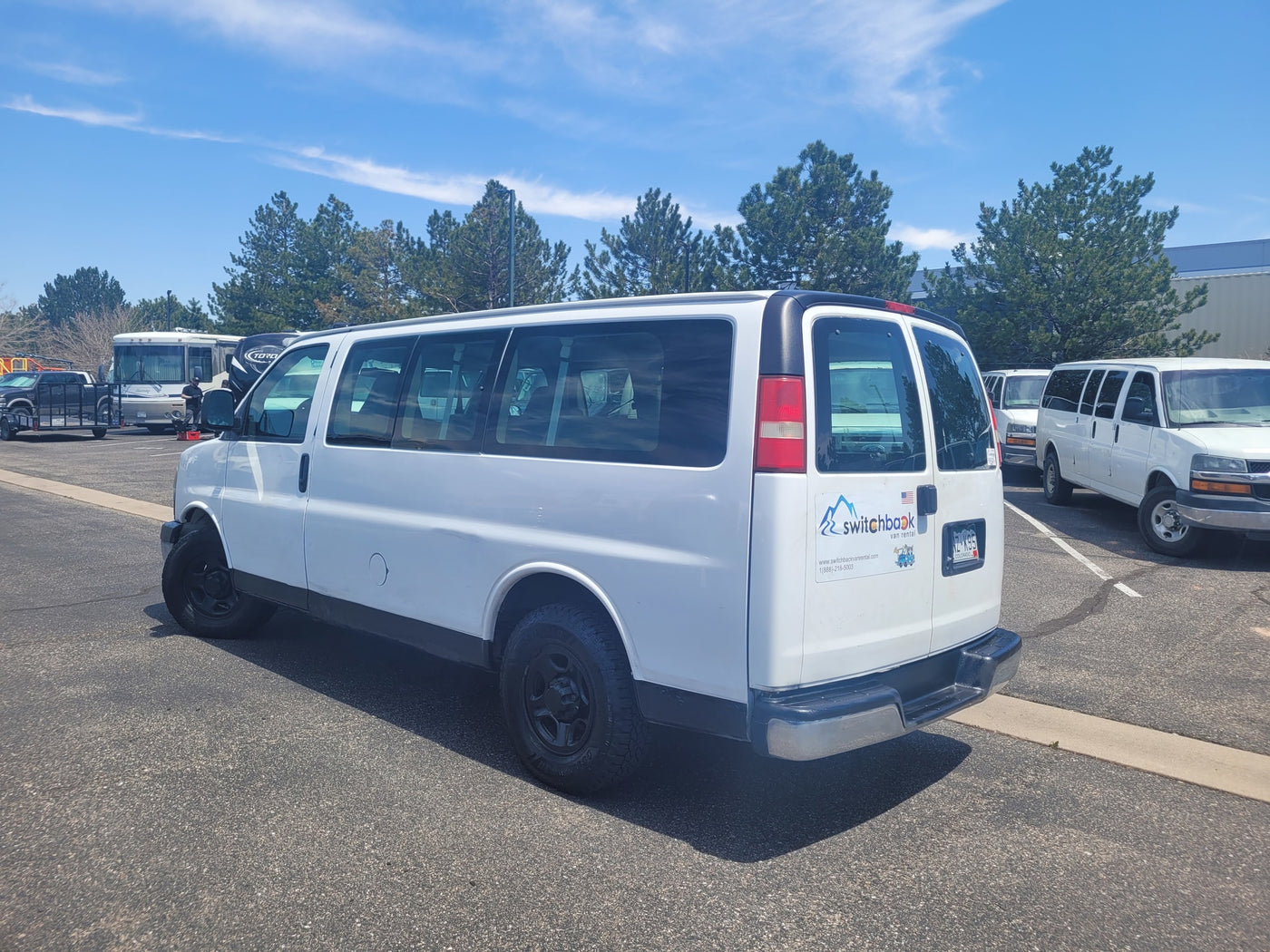  looking out at other vans. Ideal for an RV rental fleet.|White Chevrolet Express passenger van in a sunny parking lot — photo 12