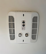Stay cool in your RV rental! Ceiling-mounted Coleman Mach climate control unit with fan/temp knobs, vents & light switch.