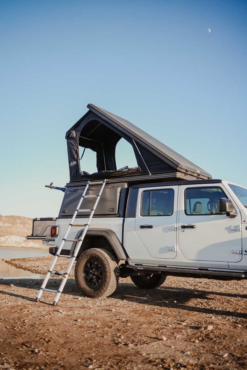 White Jeep Gladiator with a pop-up rooftop tent & ladder, perfect for your next overlanding RV rental adventure by the water. — photo 13