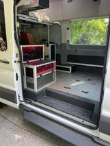 RV rental: Custom van interior with modular bed, visible LiFePo battery power, and versatile anchor-point floor.
