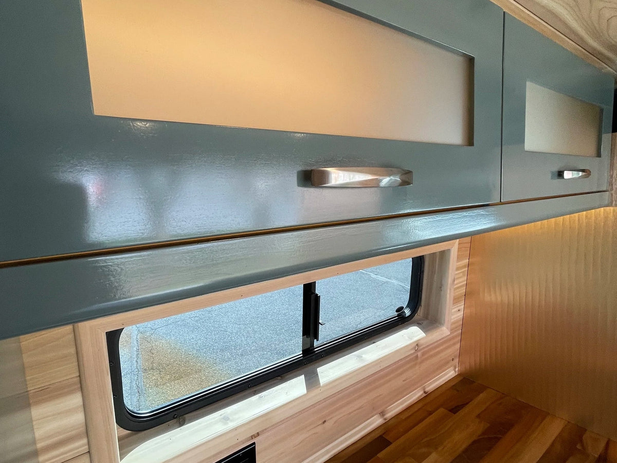  with blooming trees and a sunny sky outside.|RV rental: Bright kitchen area with wood countertops — photo 7