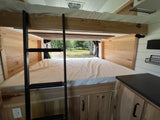 RV rental features stacked bunk beds, ladder, custom wood interior, and a wide rear window view.
