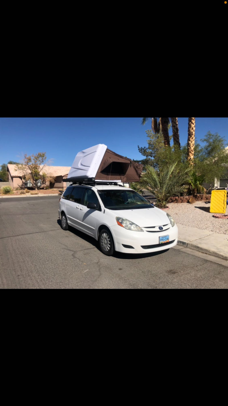  mountainous campsite. Consider this unique **rv rental** for camping!|Ready for an rv rental adventure? See this white minivan with a brown rooftop tent & ladder — photo 5