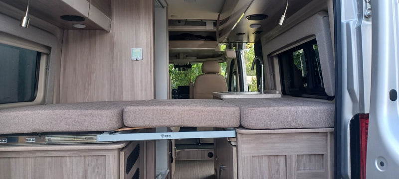  parked among trees.|This RV rental floor plan shows a compact layout with a pull-out bed — photo 5