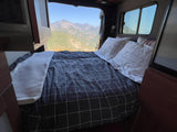 Relax in this RV rental bed with a striking mountain view from your mobile home. Perfect for scenic travels.