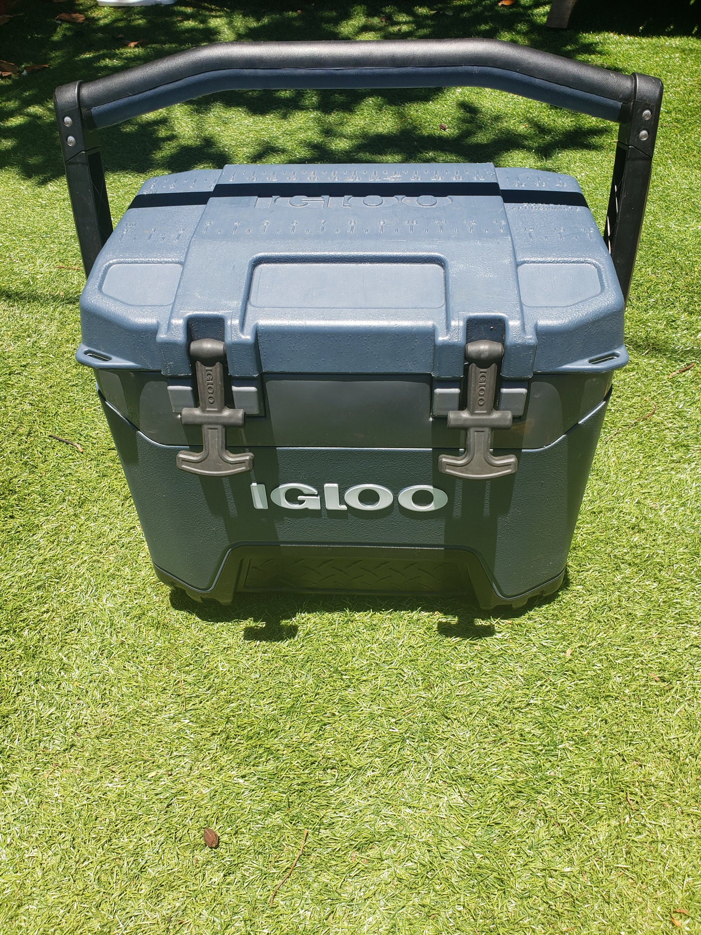 Dark grey Igloo cooler on artificial grass. Perfect for RV rental trips & outdoor adventures, keeping drinks cold on the go.