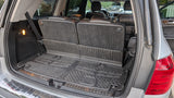 Spacious SUV cargo area with folded third-row seats, rubber mats, and a 12V outlet, ready for any rv rental trip.