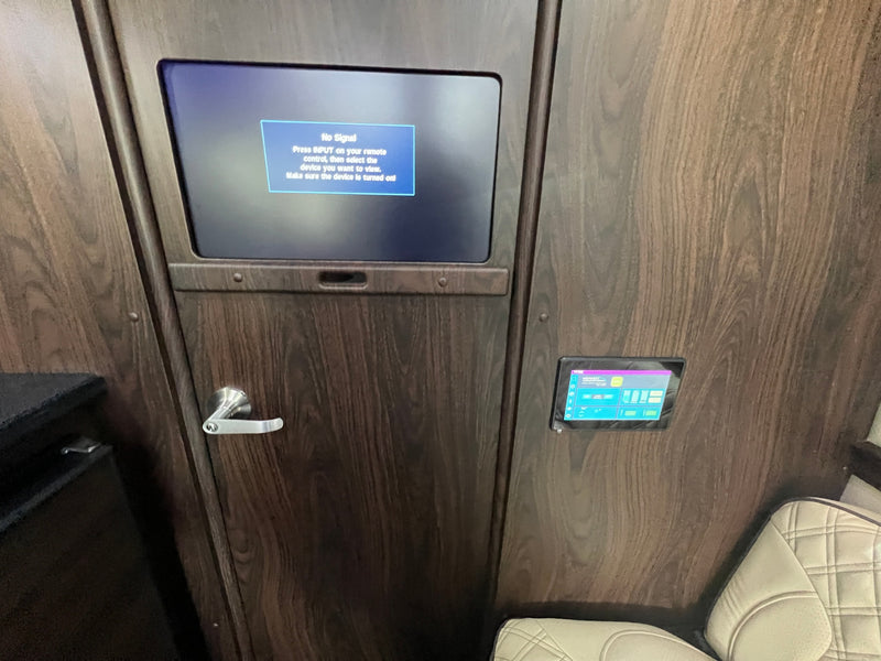 Luxury RV rental interior: a wood-paneled wall features a "No Signal" screen, door, and a modern digital control panel. — photo 14