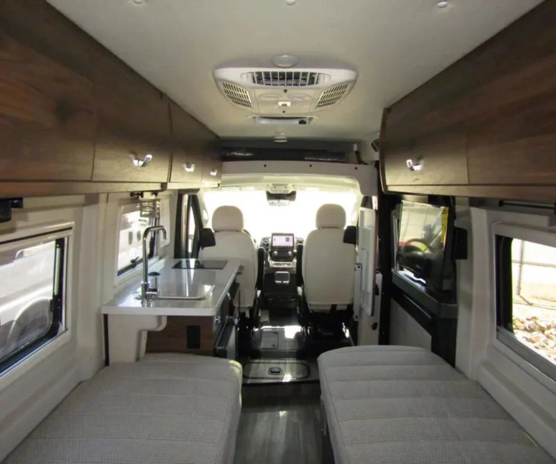  under a blue sky.|Cozy RV rental bedroom with twin beds featuring orange quilts — photo 9