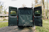 Discover this RV rental van with its rear doors open, revealing a blackout privacy screen and organized interior.