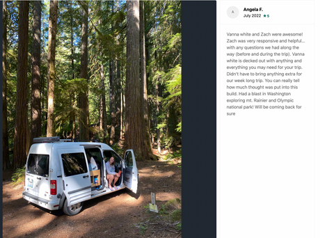 A happy traveler enjoys a white RV rental (campervan) at a peaceful forest campsite. Perfect for exploring national parks!