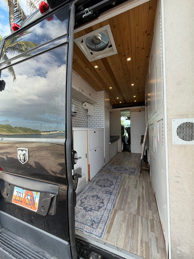  parked under palm trees on a tropical day.|Cozy RV rental interior with wooden ceiling — photo 4